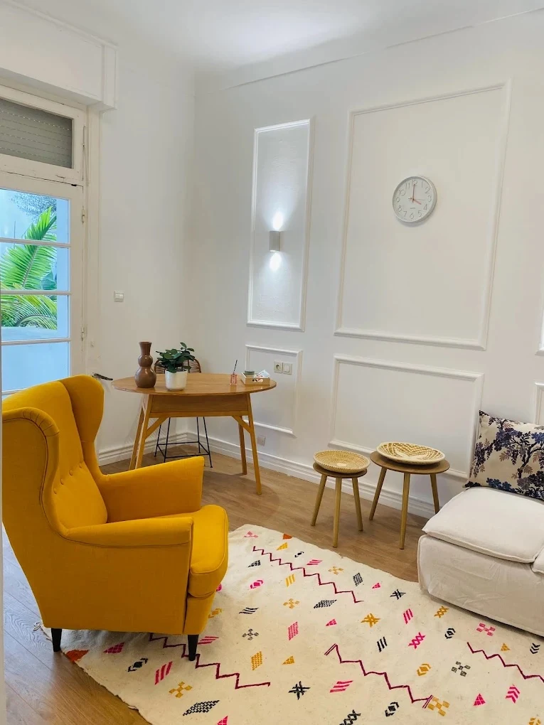 Salle de consultation — fauteuil moutarde et tapis berbère
